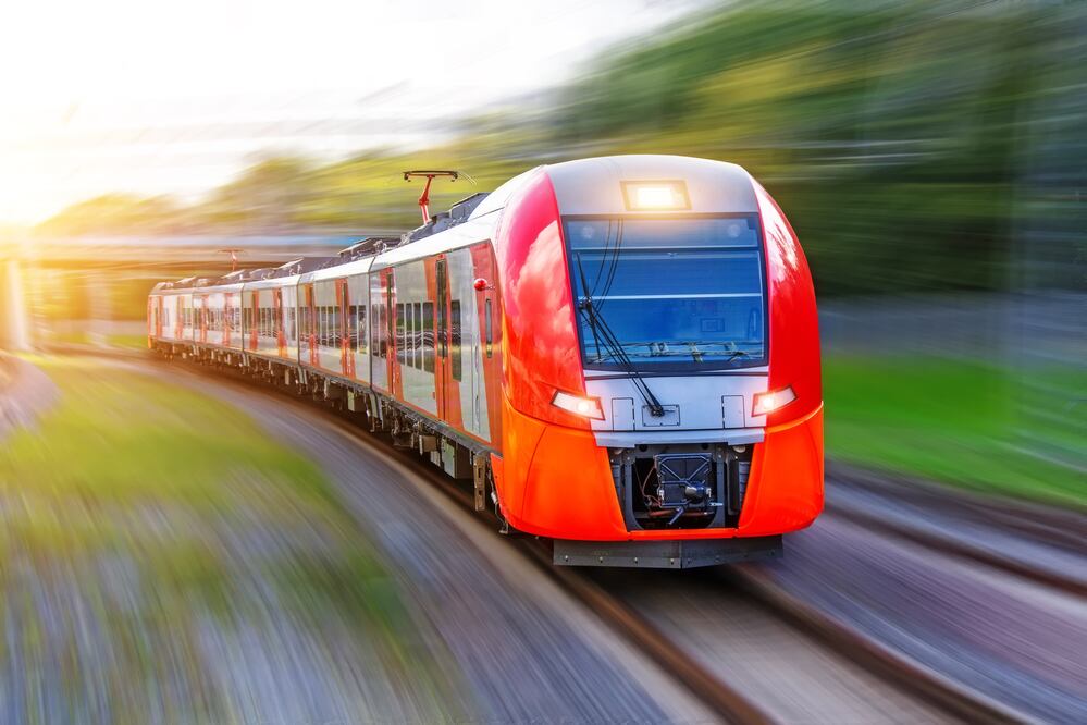 Passenger electric train rides at high speed on the turn of the railway line